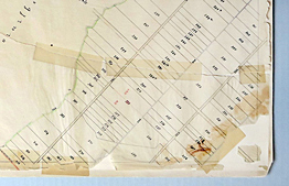 Bauplan auf Transparentpapier, der in der Mitte gerissen ist und mehrere Bruchfalten und Knicke aufweist